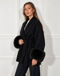Belted shawl-collar coat in black, worn by a model