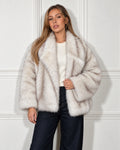 Oversized faux fur jacket in cream, worn by a model with wide-leg jeans
