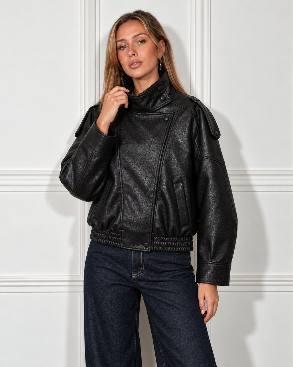 Cropped leather moto jacket in black, worn by a model with wide-leg jeans