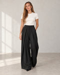 Pleated wide-leg trousers in black, worn by a model