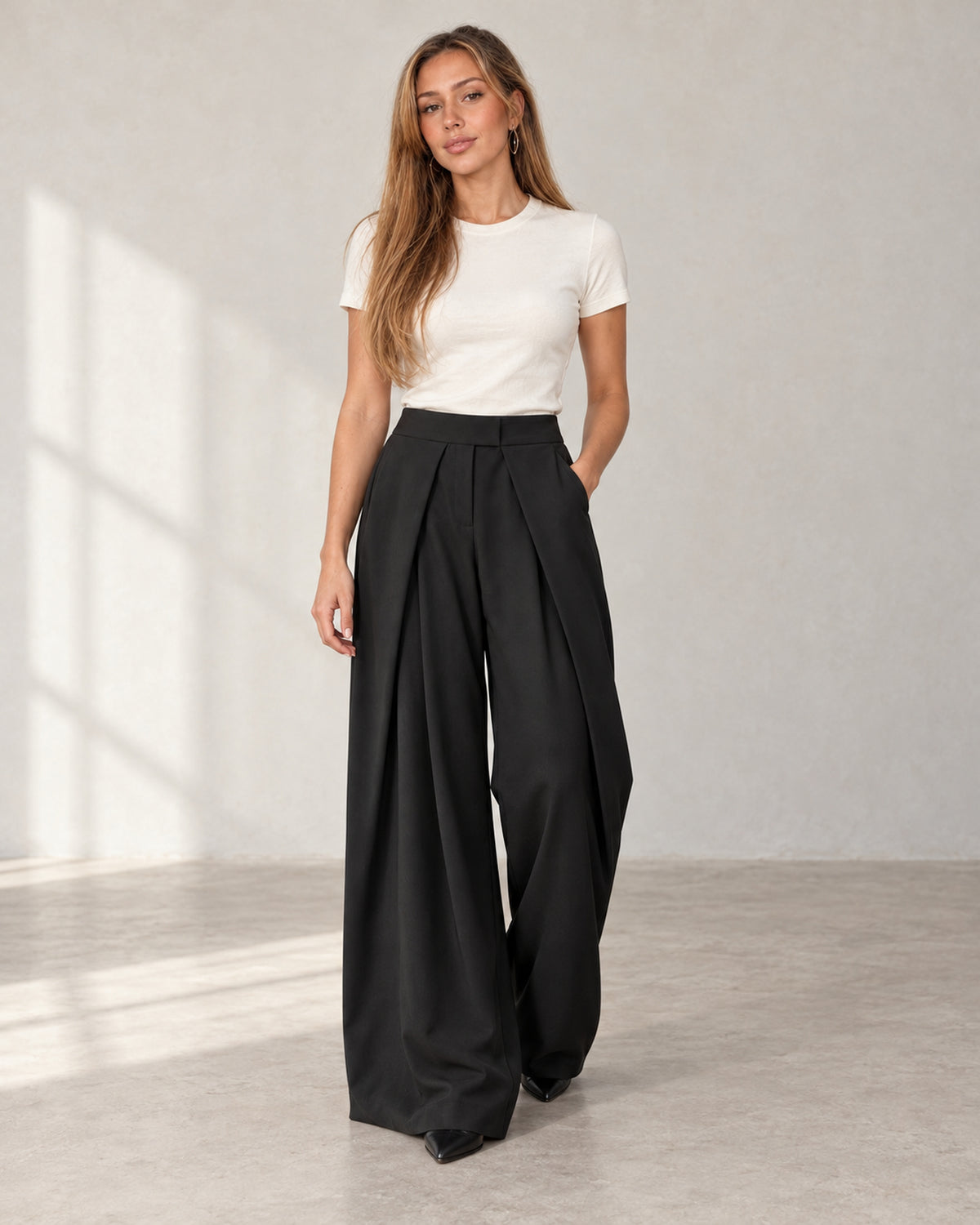 Pleated wide-leg trousers in black, worn by a model