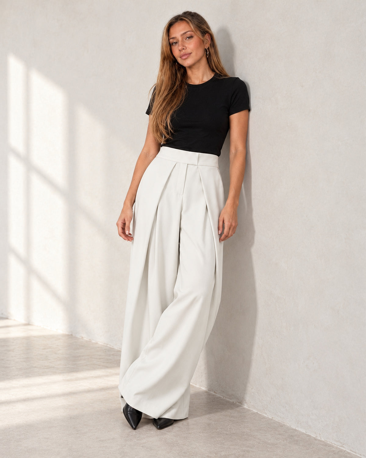 Pleated wide-leg trousers in white, worn by a model