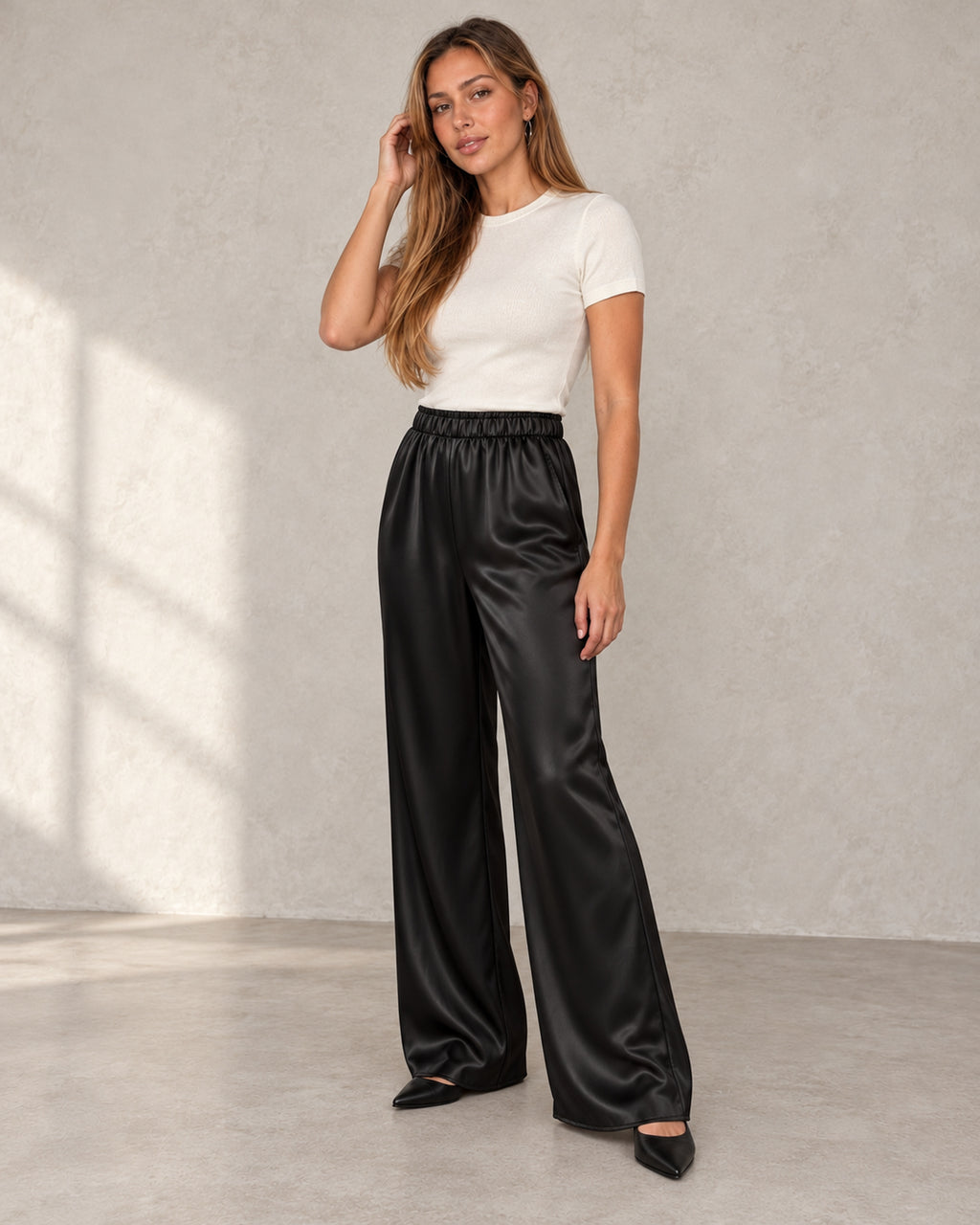 Satin wide-leg trousers in black, worn by a model